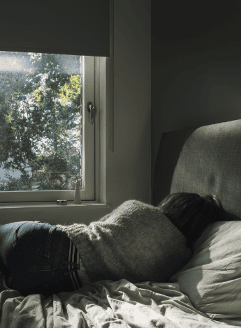Woman lying in bed looking depressed